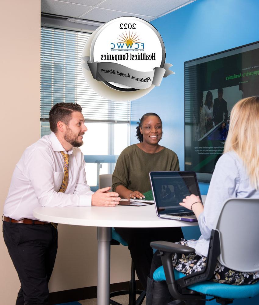 People seating around an office table and a FCWWC seal behind them.